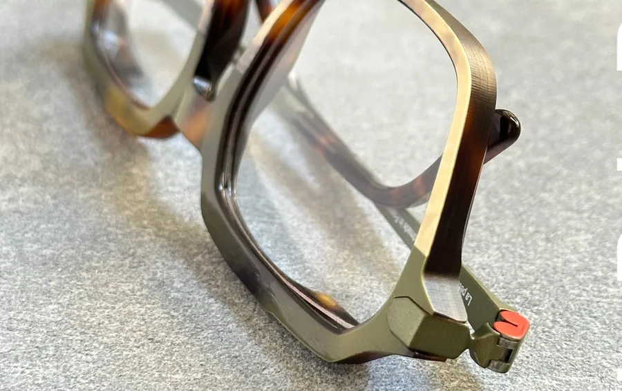 Charnière de monture La Petite Lunette Rouge, avec son détail rouge caractéristique et une gravure du nom de la maison sur la branche