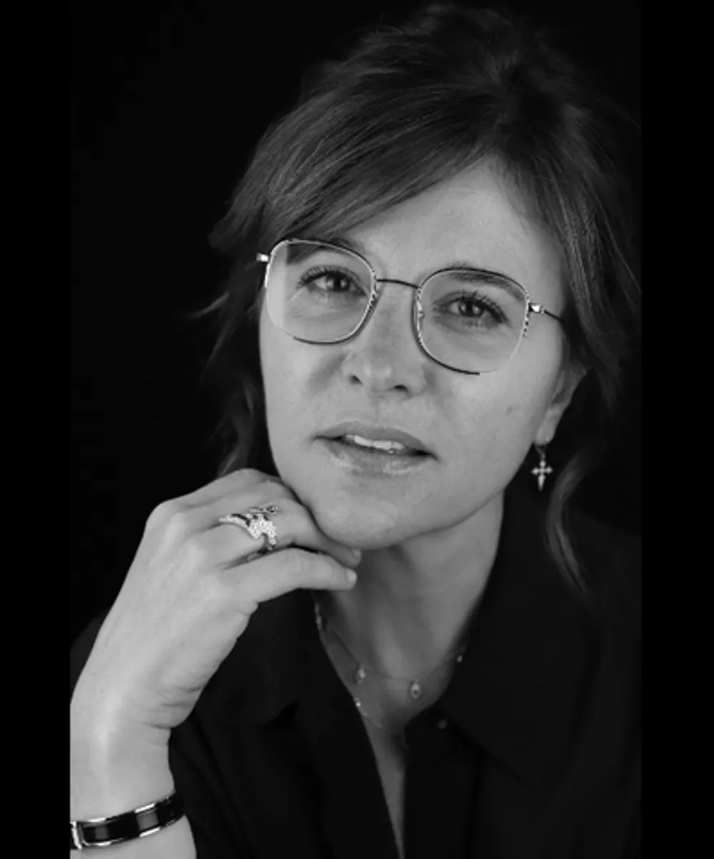Portrait en noir et blanc de Nathalie Blanc, créatrice de lunettes, portant une monture ronde de sa collection