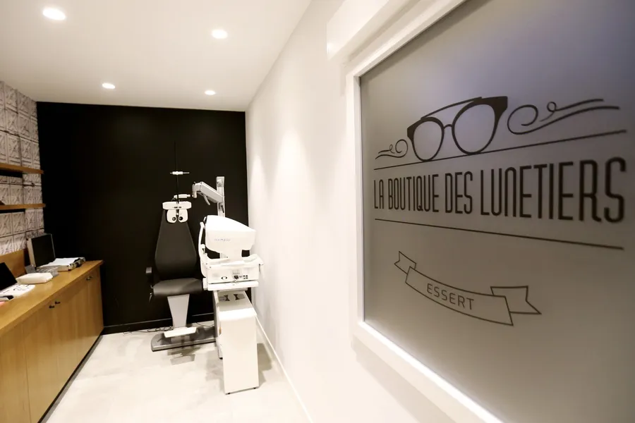Salle d'examen de la vue de La Boutique des Lunetiers, à Essert, avec l'enseigne de la boutique visible sur la vitre