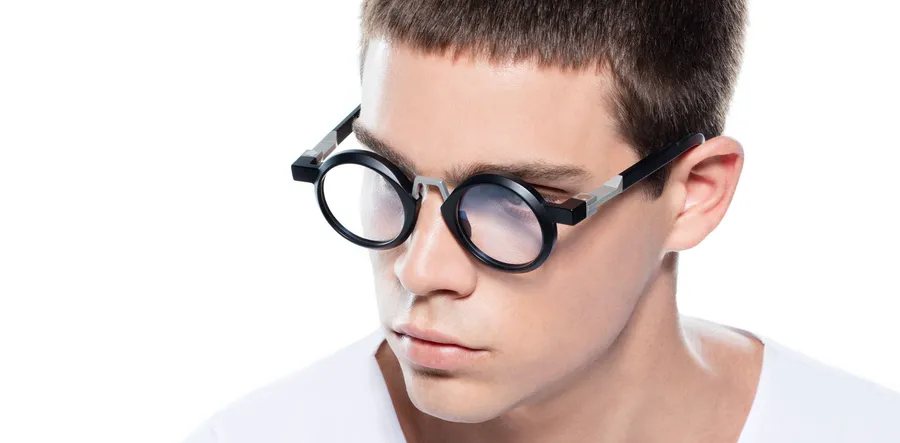 Portrait rapproché d’un homme portant une monture optique ronde noire VAVA Eyewear, charnière métallique apparente