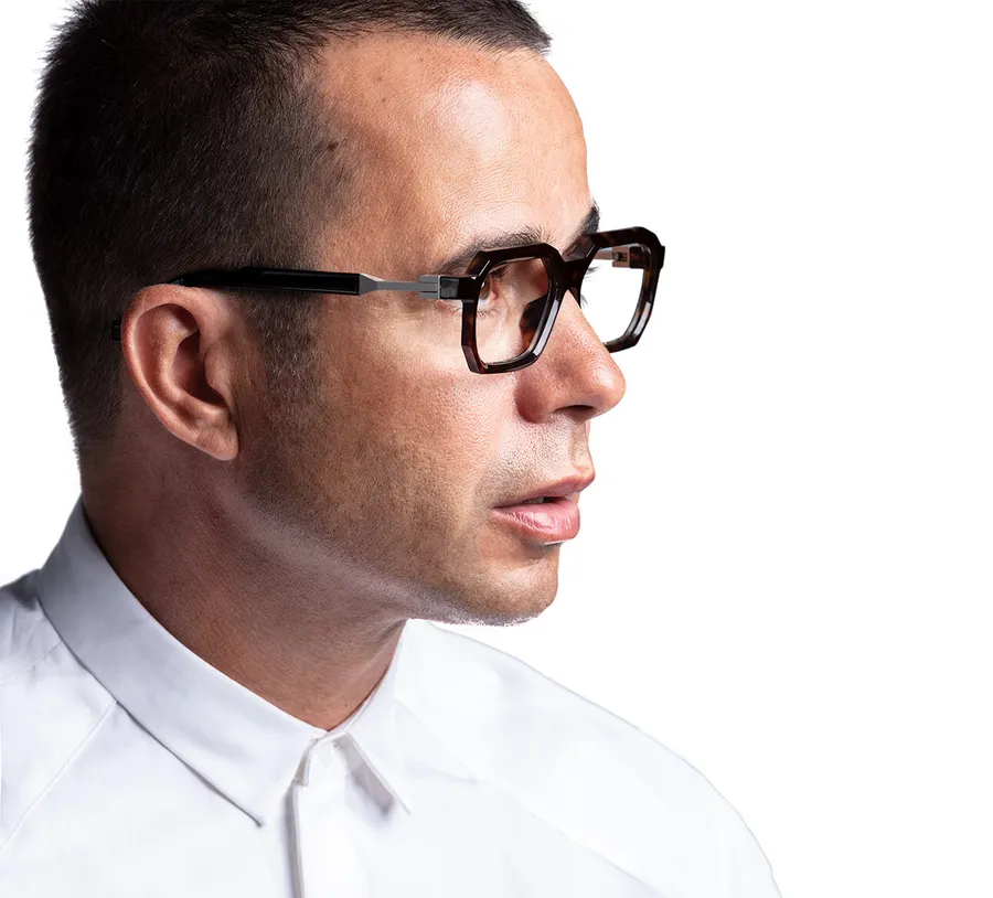 Portrait de profil de Pedro da Silva, fondateur et designer de VAVA Eyewear, portant une monture optique écaille à la charnière métallique apparente