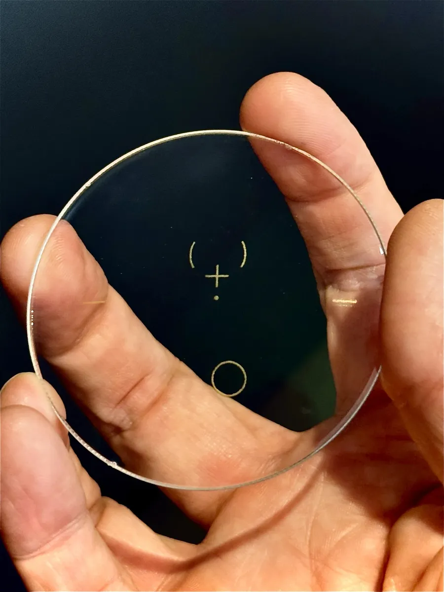 Verre progressif tenu à la main, gravures de repérage visibles